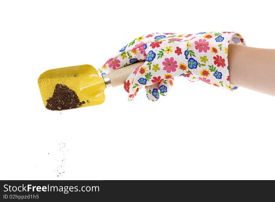 Gardener wearing colorful flower patterned  gardening glove is using a yellow shovel with soil in it.  isolated on white 6253. Gardener wearing colorful flower patterned  gardening glove is using a yellow shovel with soil in it.  isolated on white 6253