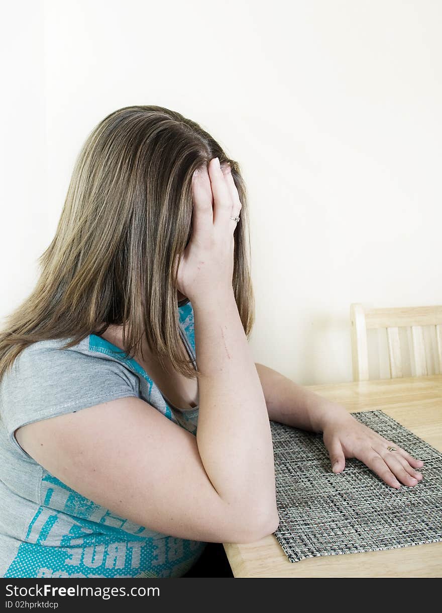 Depressed woman sitting at the table.