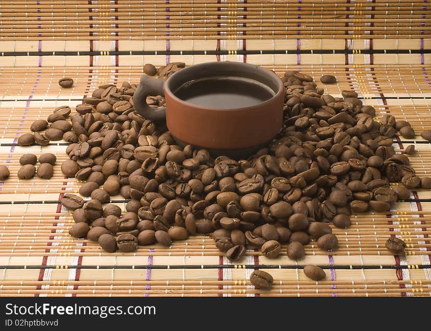 A cup of coffee among coffee beans