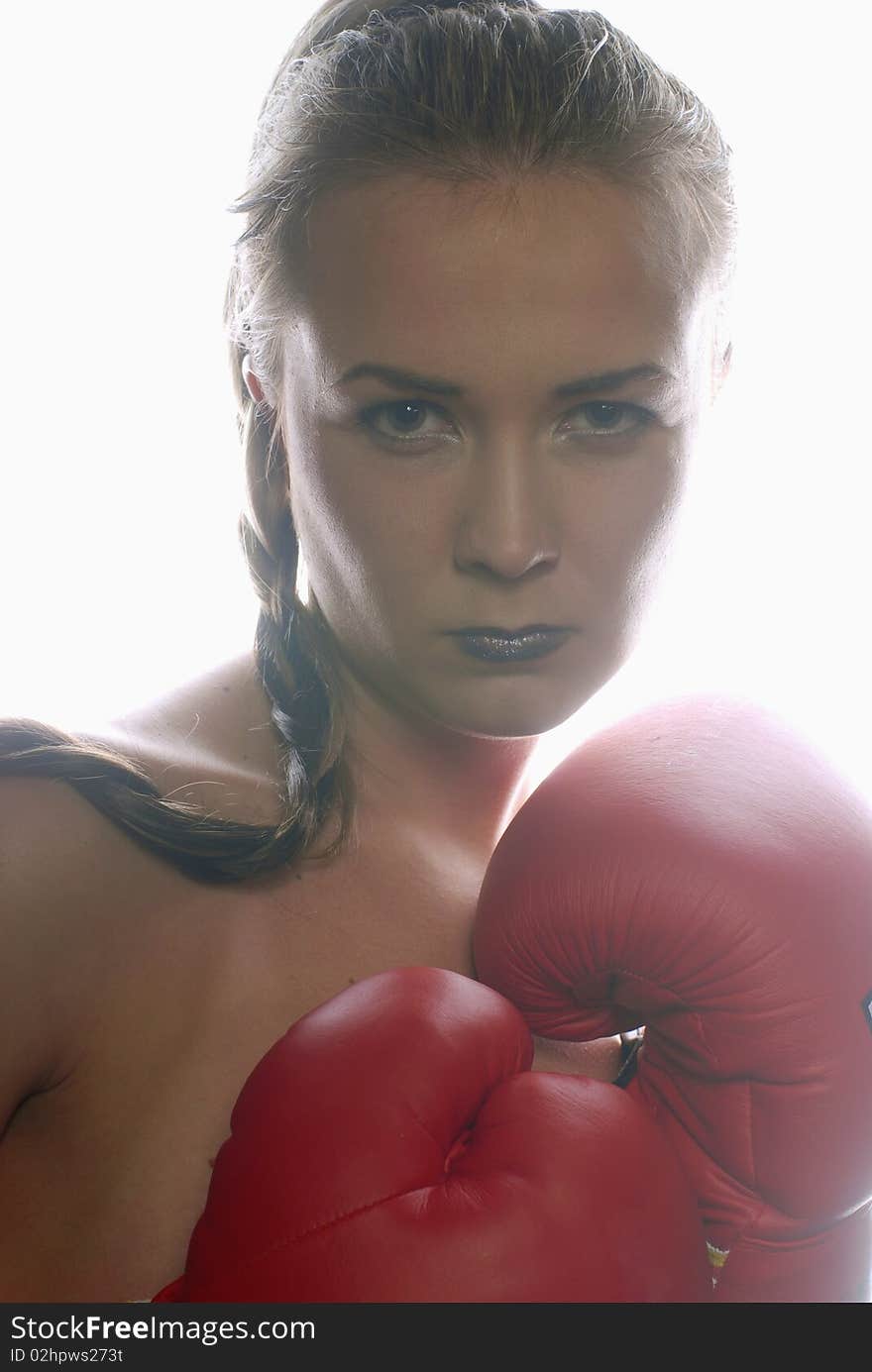 Woman in boxing gloves illuminated with backlight