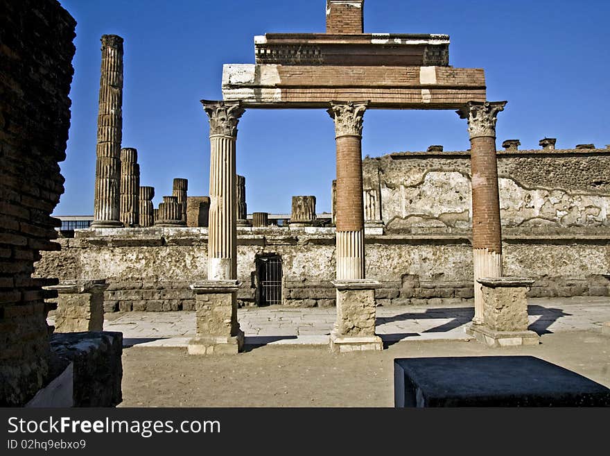 Ancient ruins of a public square in Pompeii with Corinthian columns holding whats left of a roofline. Ancient ruins of a public square in Pompeii with Corinthian columns holding whats left of a roofline