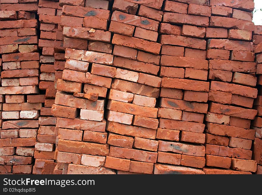 Heap of a red ceramic brick. A background on a theme about a building material.