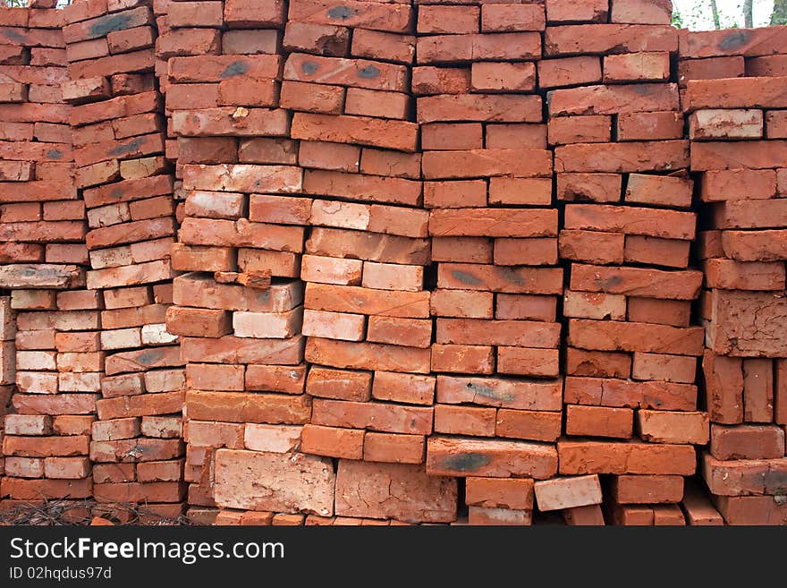 Heap of a red ceramic brick. A background on a theme about a building material.