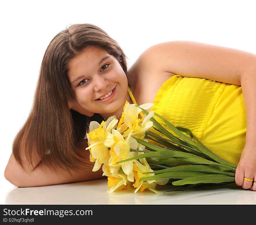 A beautiful young teen reclining in a yellow sundress while holding a bouquet of daffodils.  Isolated on white. A beautiful young teen reclining in a yellow sundress while holding a bouquet of daffodils.  Isolated on white.