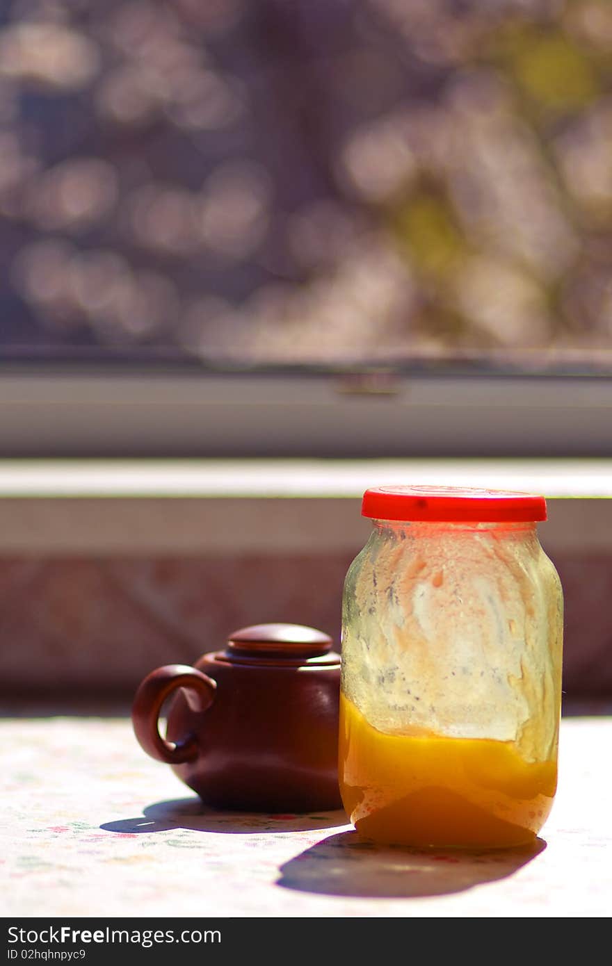 Breakfast on the sunny kitchen on spring (tea, honey, sugar, fruits)