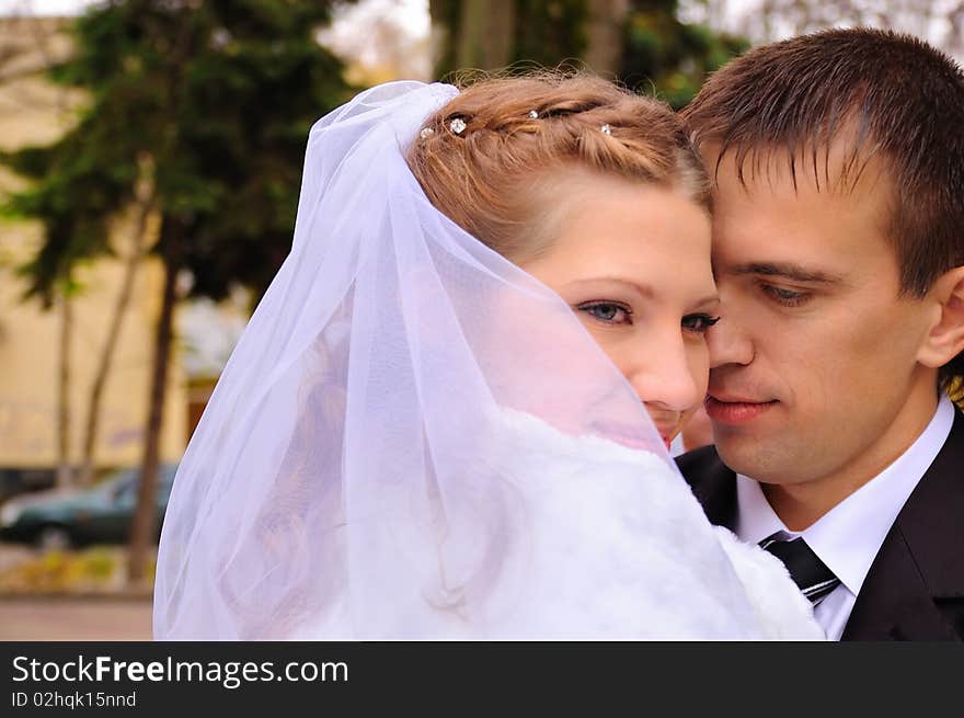 The groom and the bride embrace. The bride smiles. The groom and the bride embrace. The bride smiles