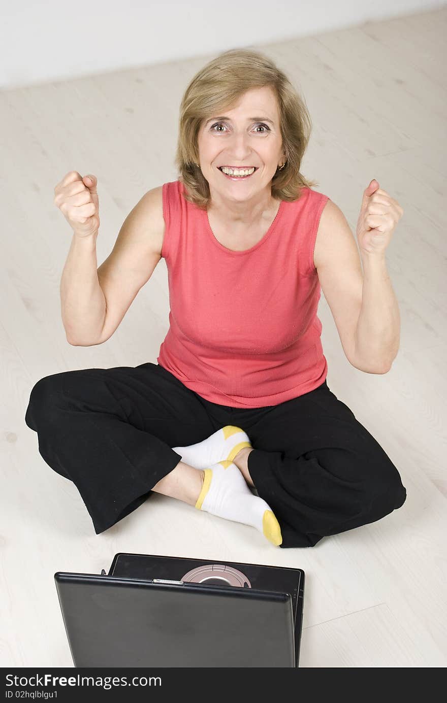 Excited senior woman having success by using laptop and gesturing,top view,see more in People on couch or wooden floor. Excited senior woman having success by using laptop and gesturing,top view,see more in People on couch or wooden floor