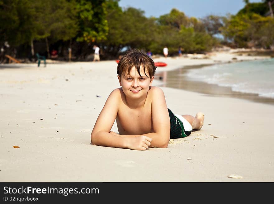 Happy boy lying at the beach