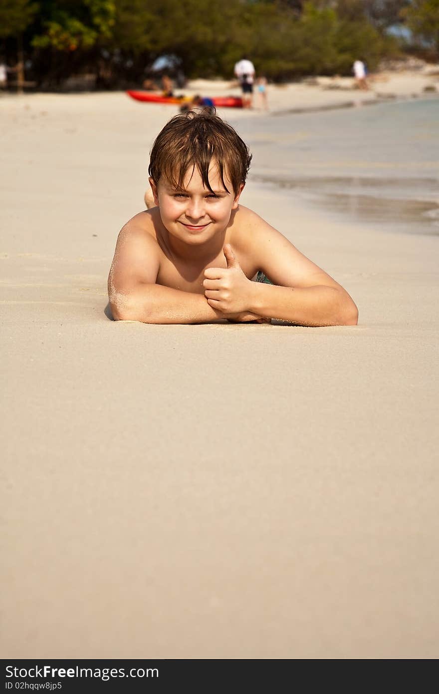 Happy Boy Lying At The Beach