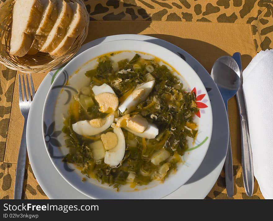 A plate of soup with eggs and bread