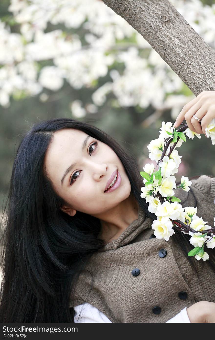 Beautiful Chinese girl holding garlands under cherry blossom tree. Beautiful Chinese girl holding garlands under cherry blossom tree.