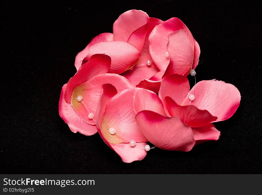 Artificial pink petals and whitw glasses on black