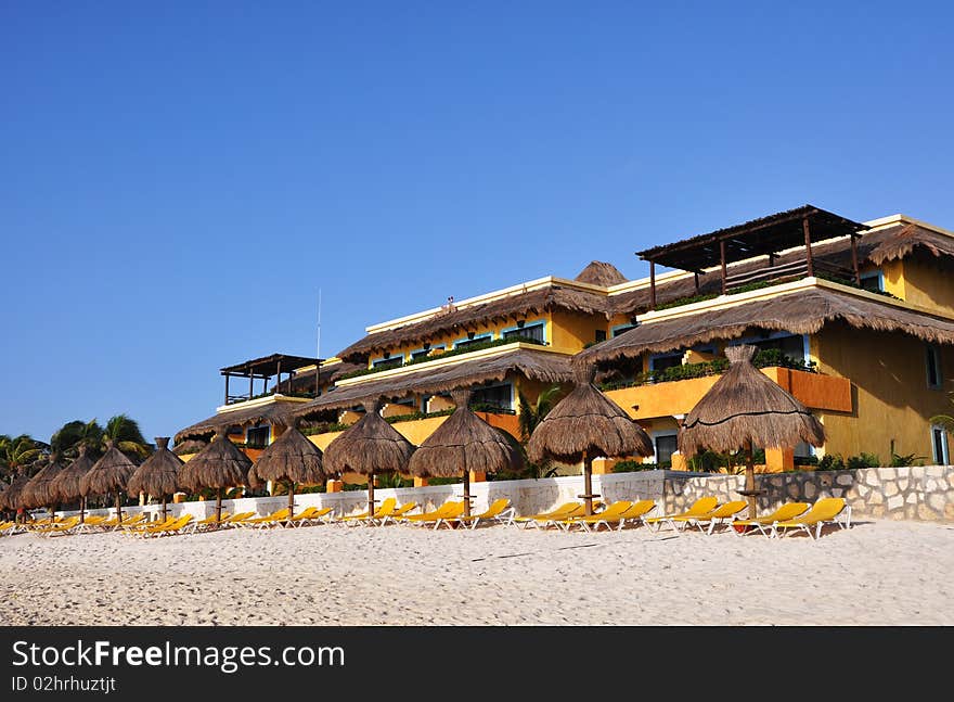 Sand, empty yellow plank beds, grassy umbrellas and the sea. Sand, empty yellow plank beds, grassy umbrellas and the sea.