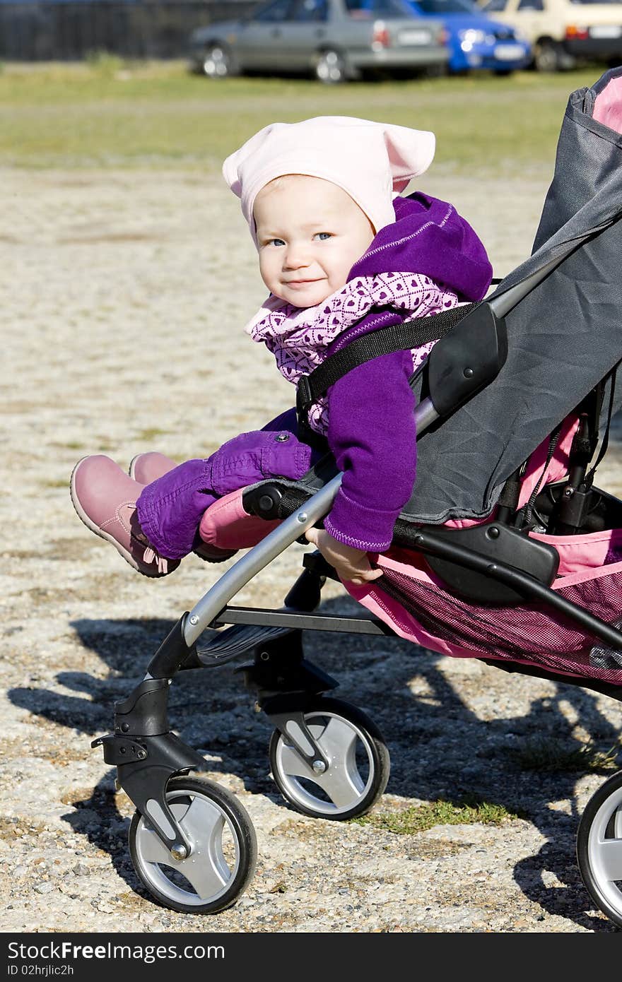 Toddler sitting in a pram on walk. Toddler sitting in a pram on walk