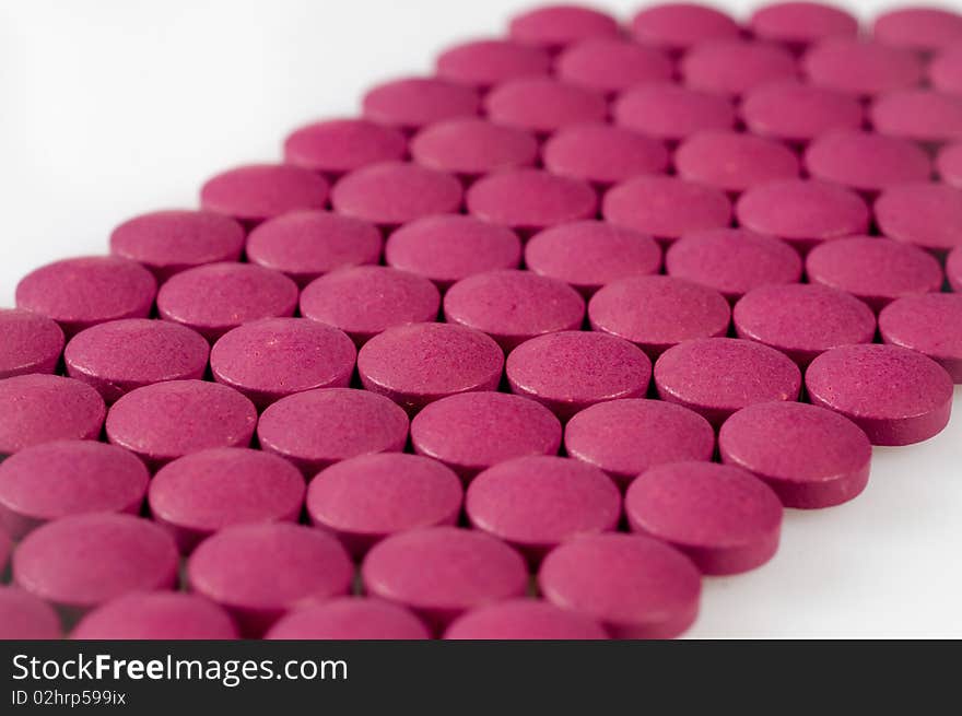 Magenta pills on a white background