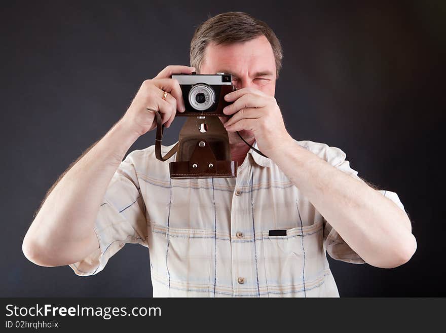 Man with the ancient camera against a dark background. Man with the ancient camera against a dark background