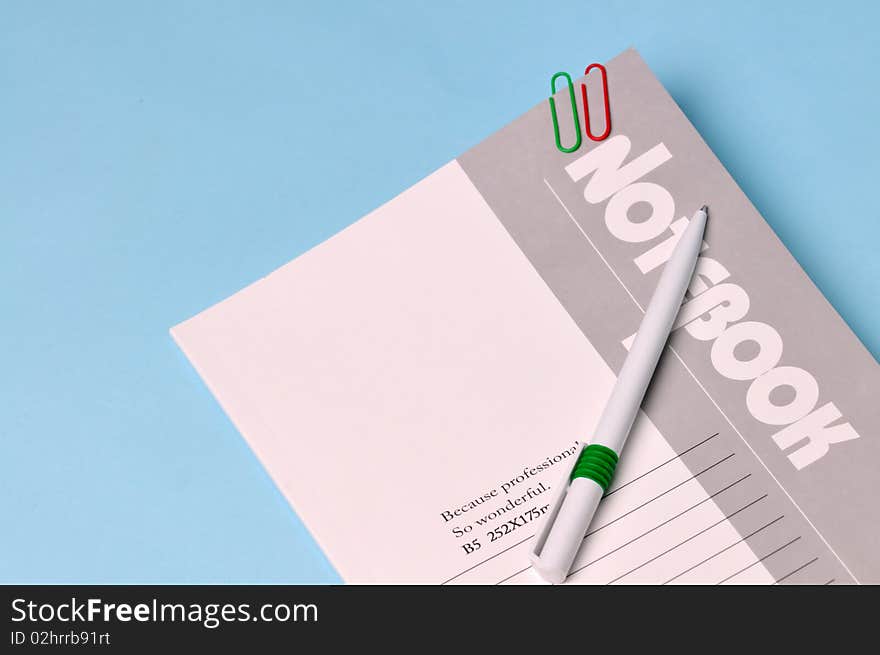 Notebook and pen in a light blue background.