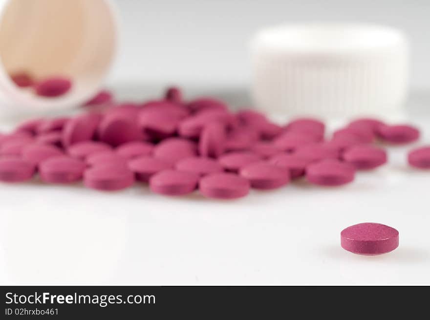 Magenta pills on a white background