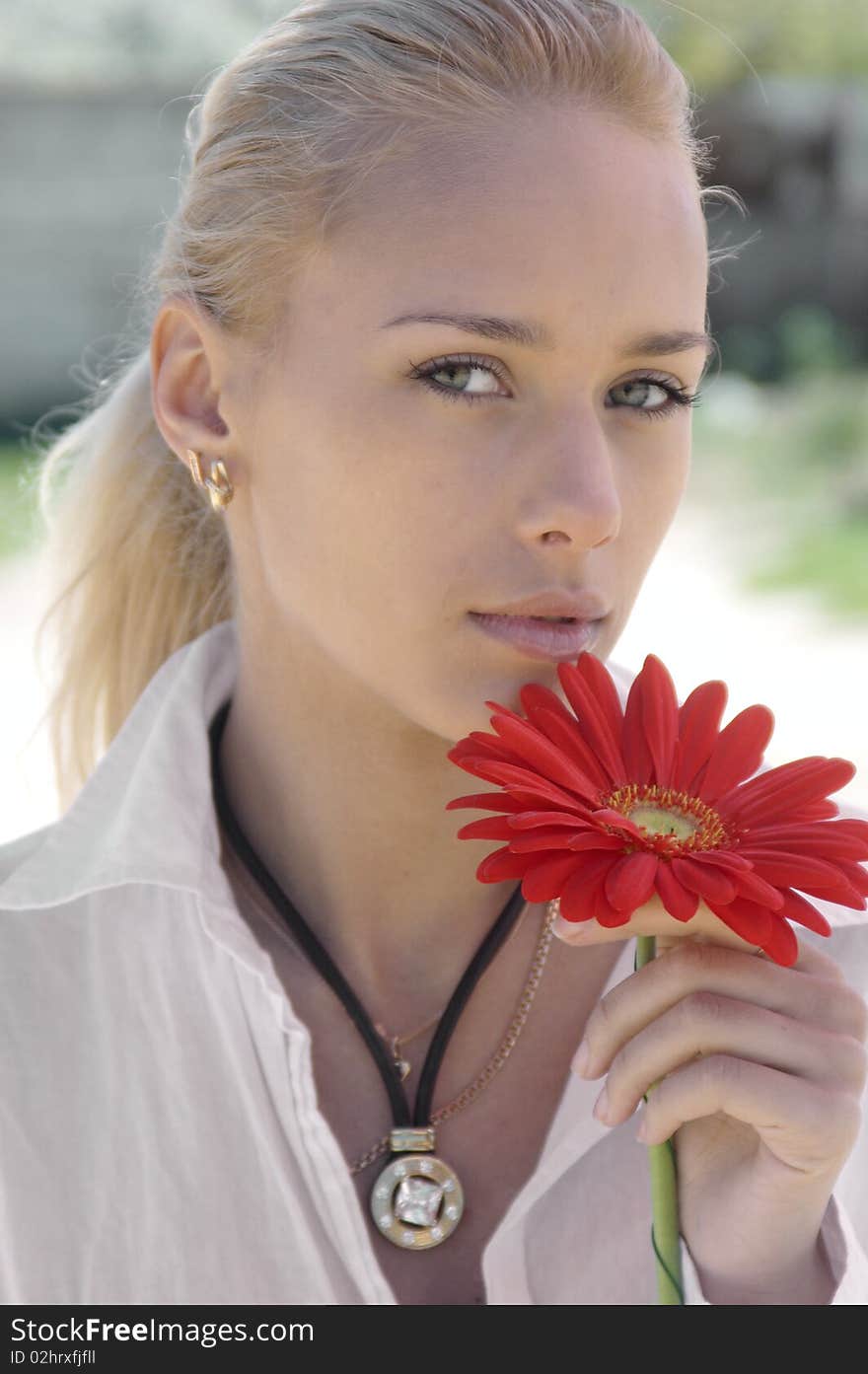 Girl in wite with a red flower outdoors. Girl in wite with a red flower outdoors