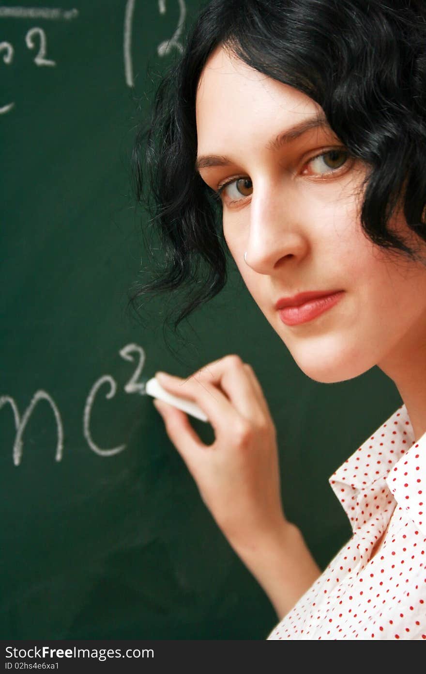 Student writing on the blackboard, mathematics lesson