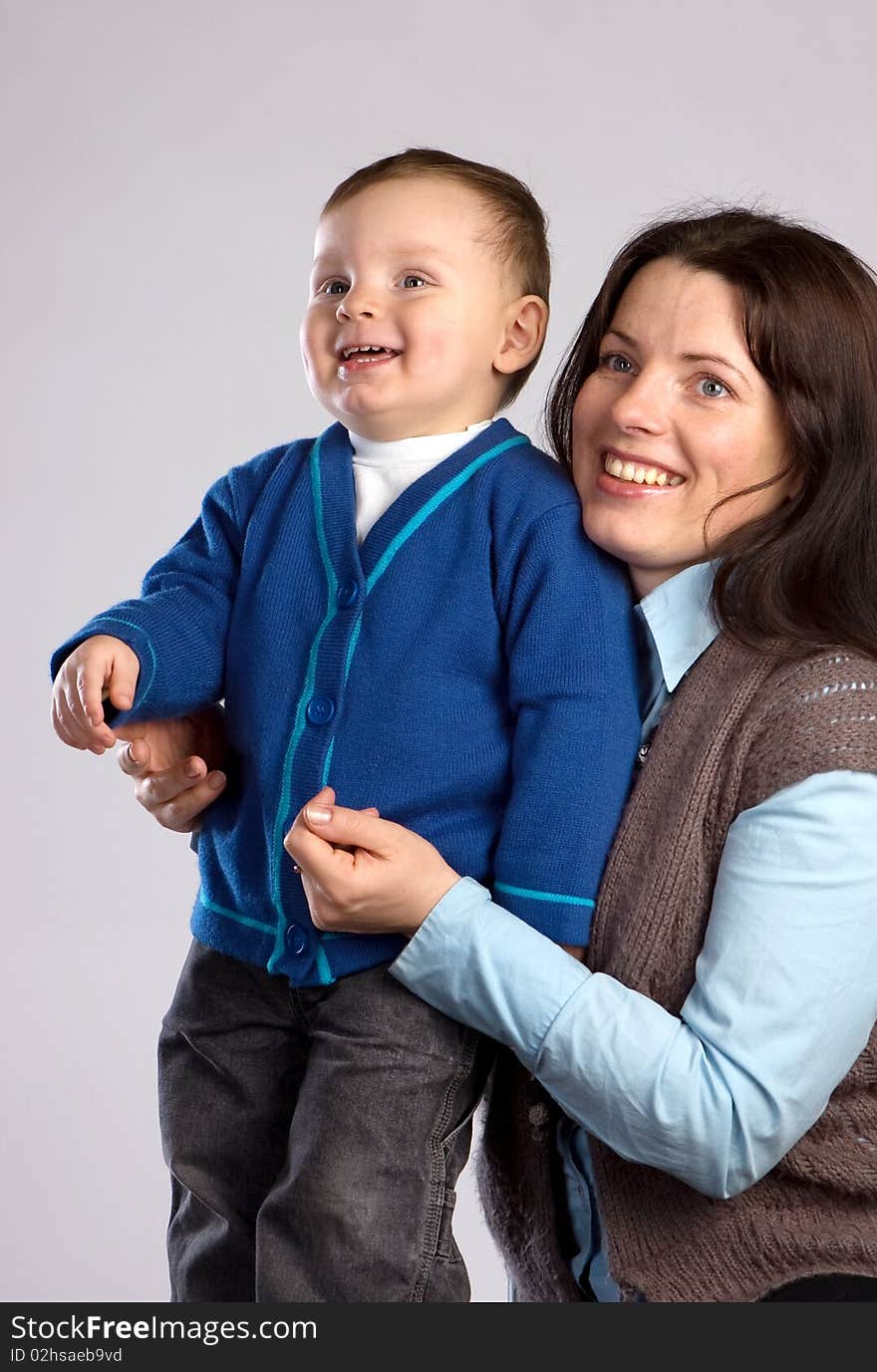 Smiling mother with son, studio shot, gray background. Smiling mother with son, studio shot, gray background