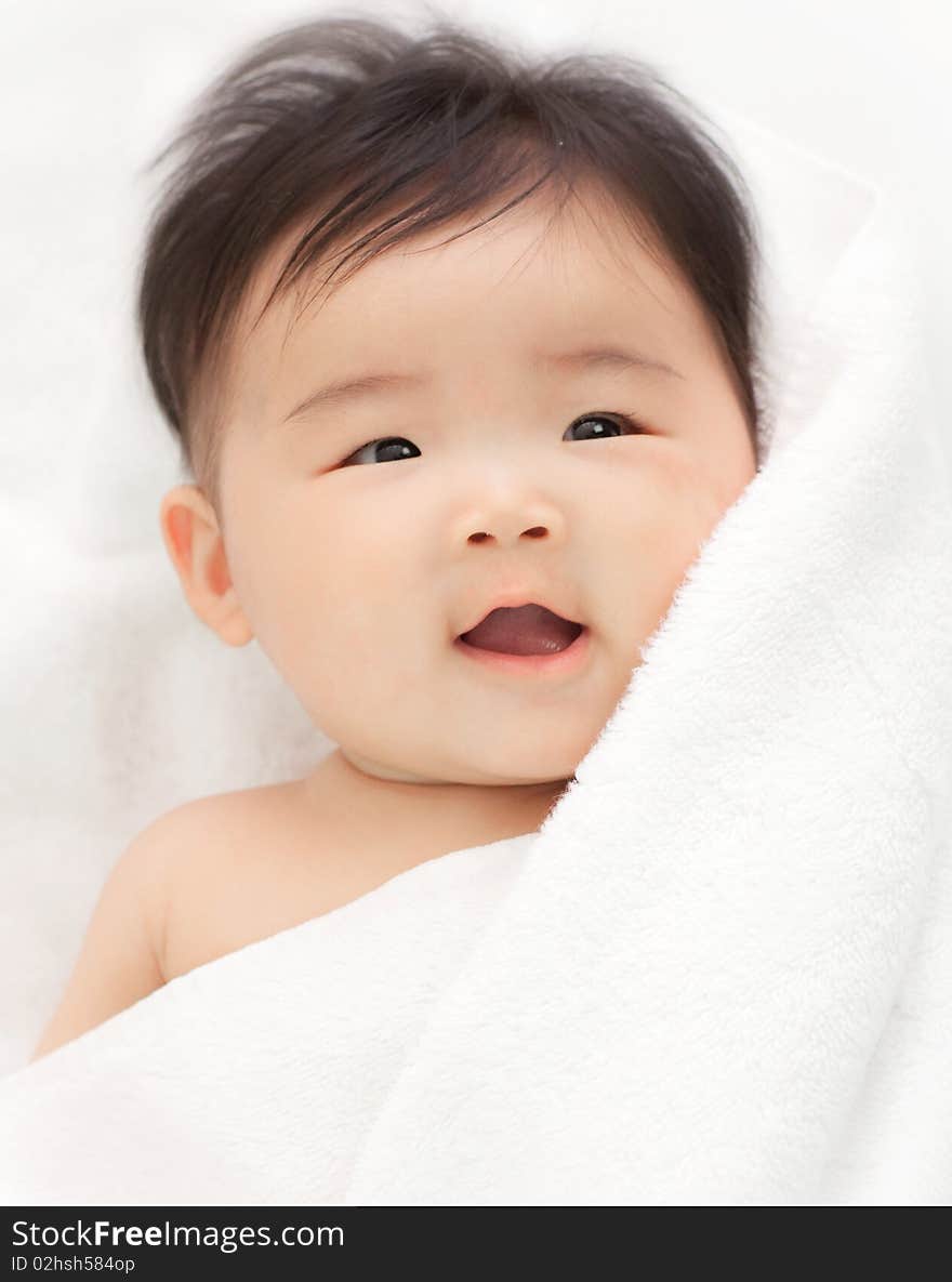 A smiling babywith her hair just dried with a towel.