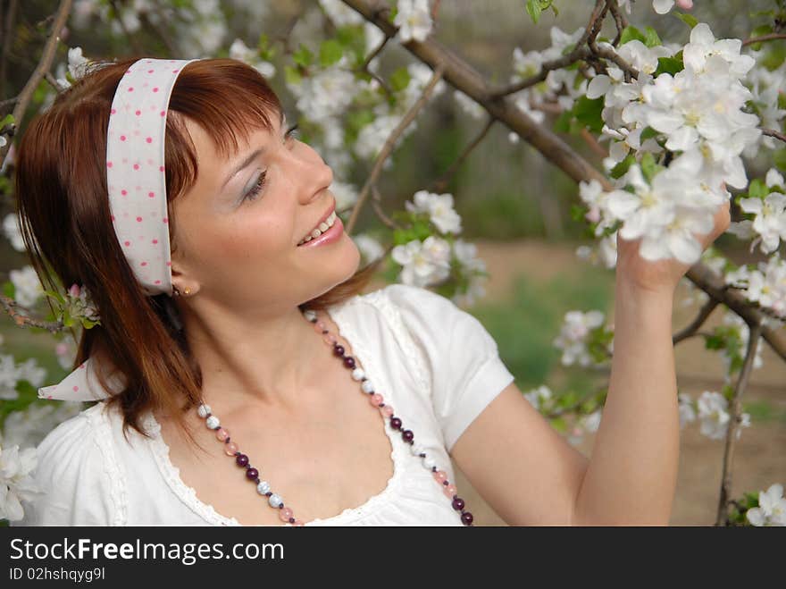 Beautiful young girl is happy flowering apple tree. Beautiful young girl is happy flowering apple tree