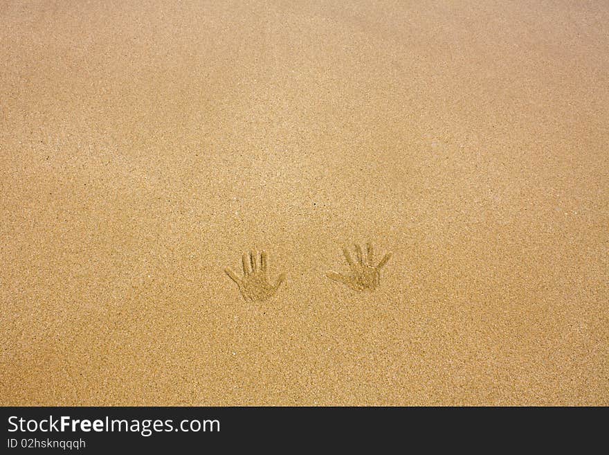 Handprints on a sandy beach