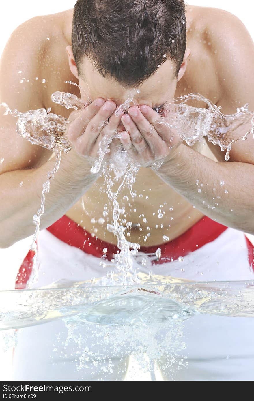 Young man washing face with clean water and representing hygiene and mans beauty concept. Young man washing face with clean water and representing hygiene and mans beauty concept