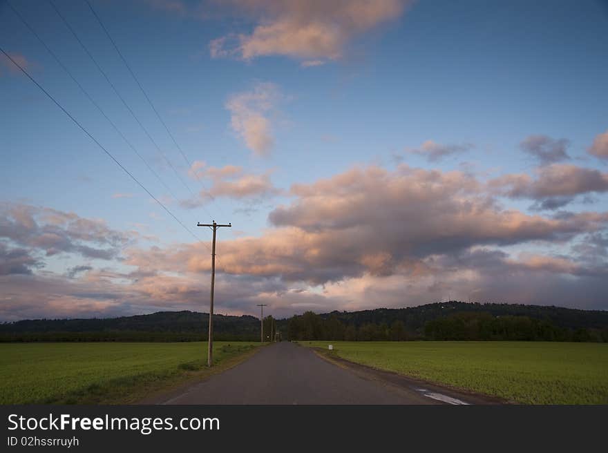 Rural highway under sunset clouds