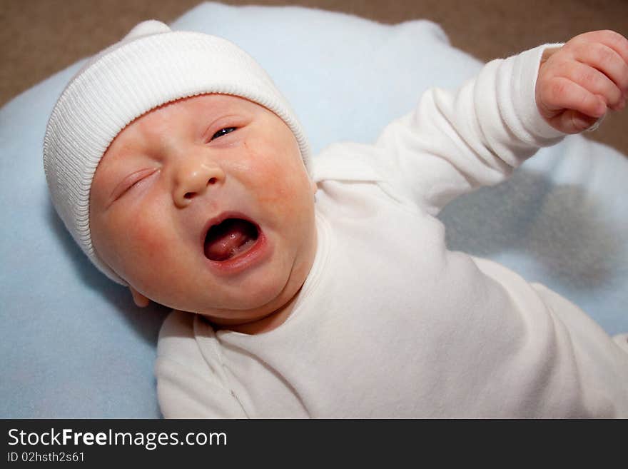 A very young baby boy child is photographed while he is 0-3 months old infant.