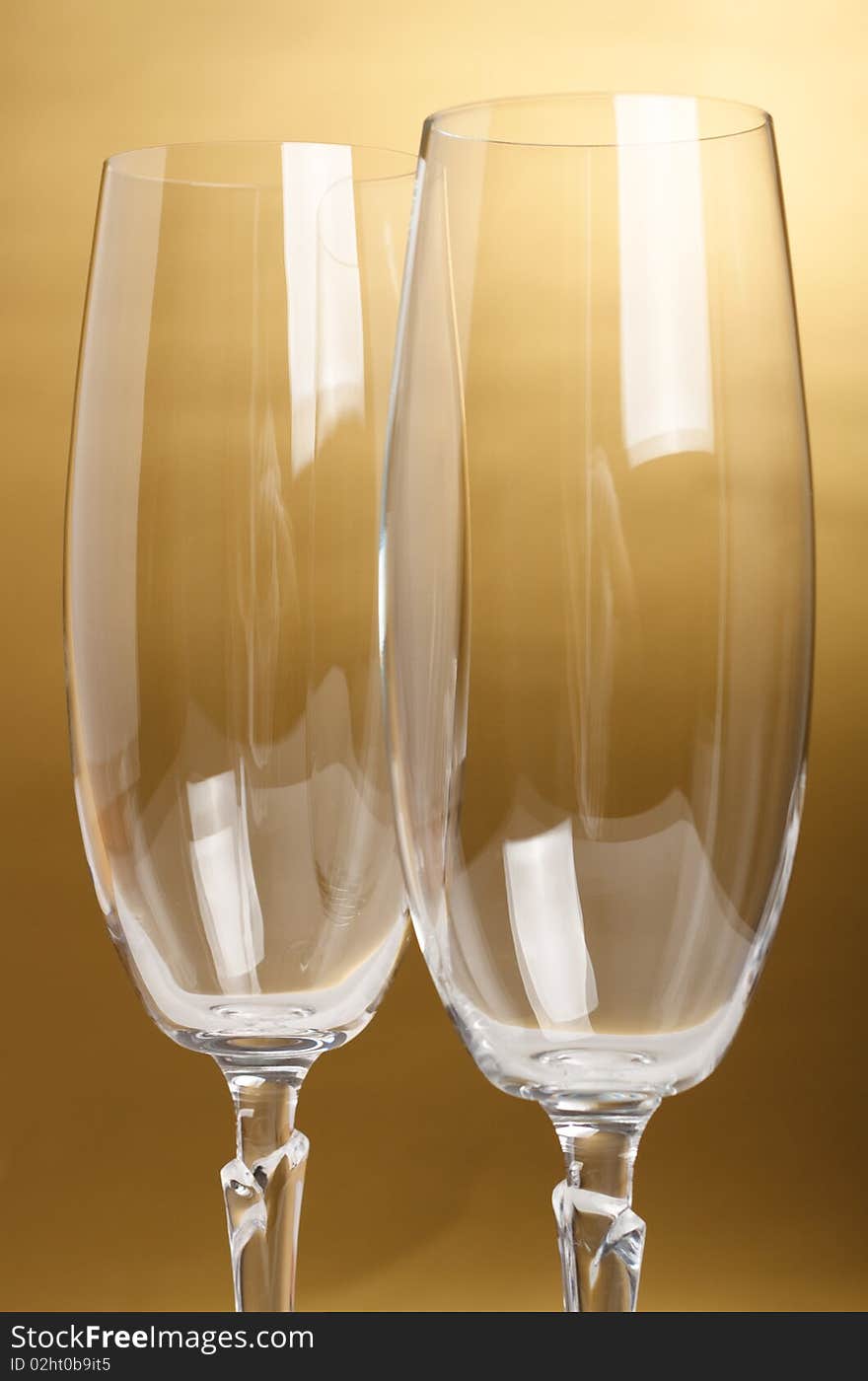 Two flutes with champagne on golden background. Two flutes with champagne on golden background