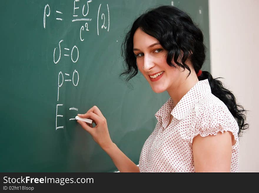 Smiling Student Writing On The Blackboard