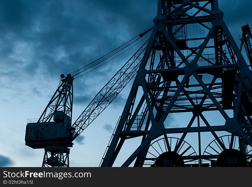 Two large dock cranes at night