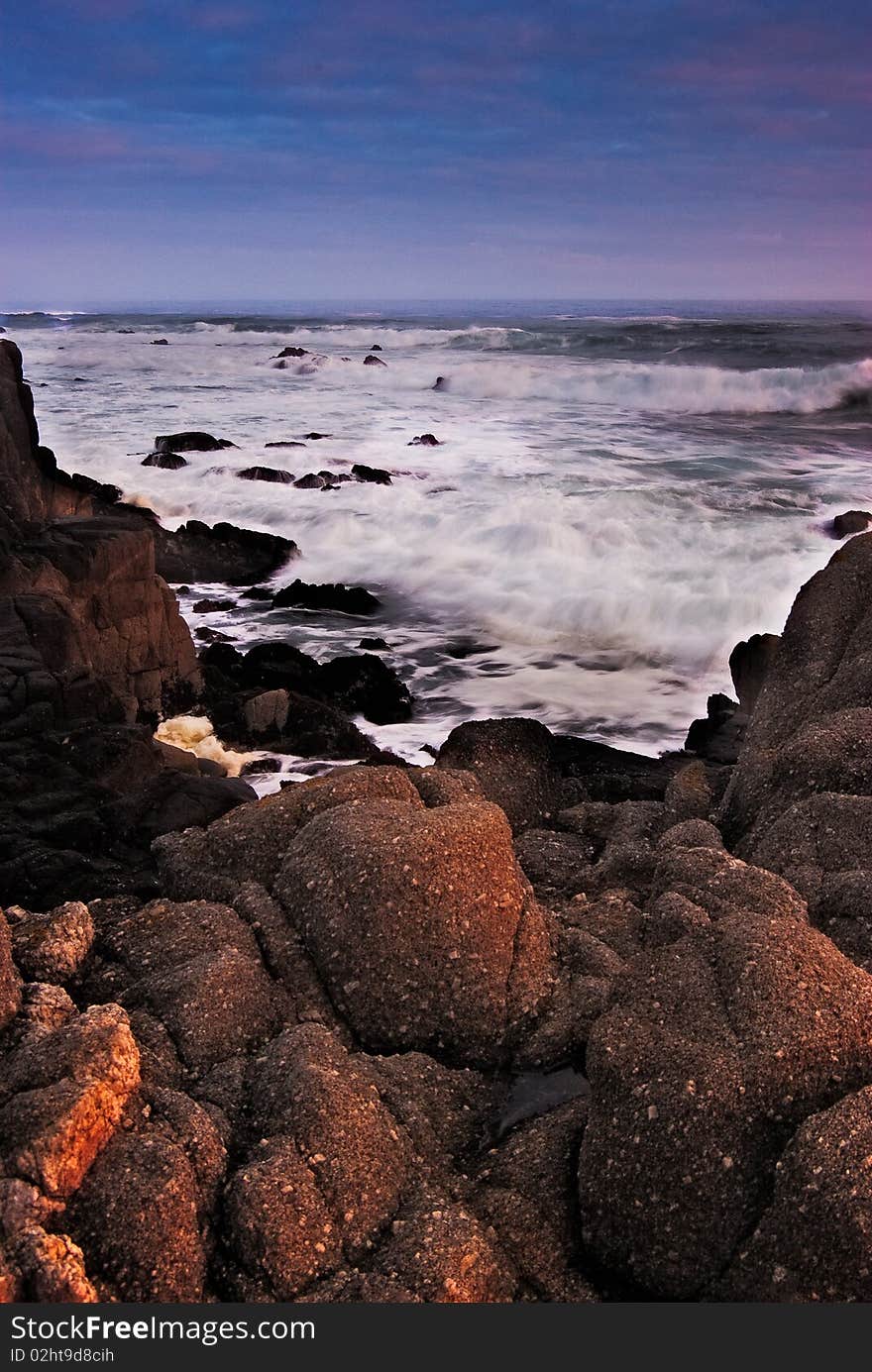 Details of the waves crashing on the beach with details of the rocks and sky. Details of the waves crashing on the beach with details of the rocks and sky