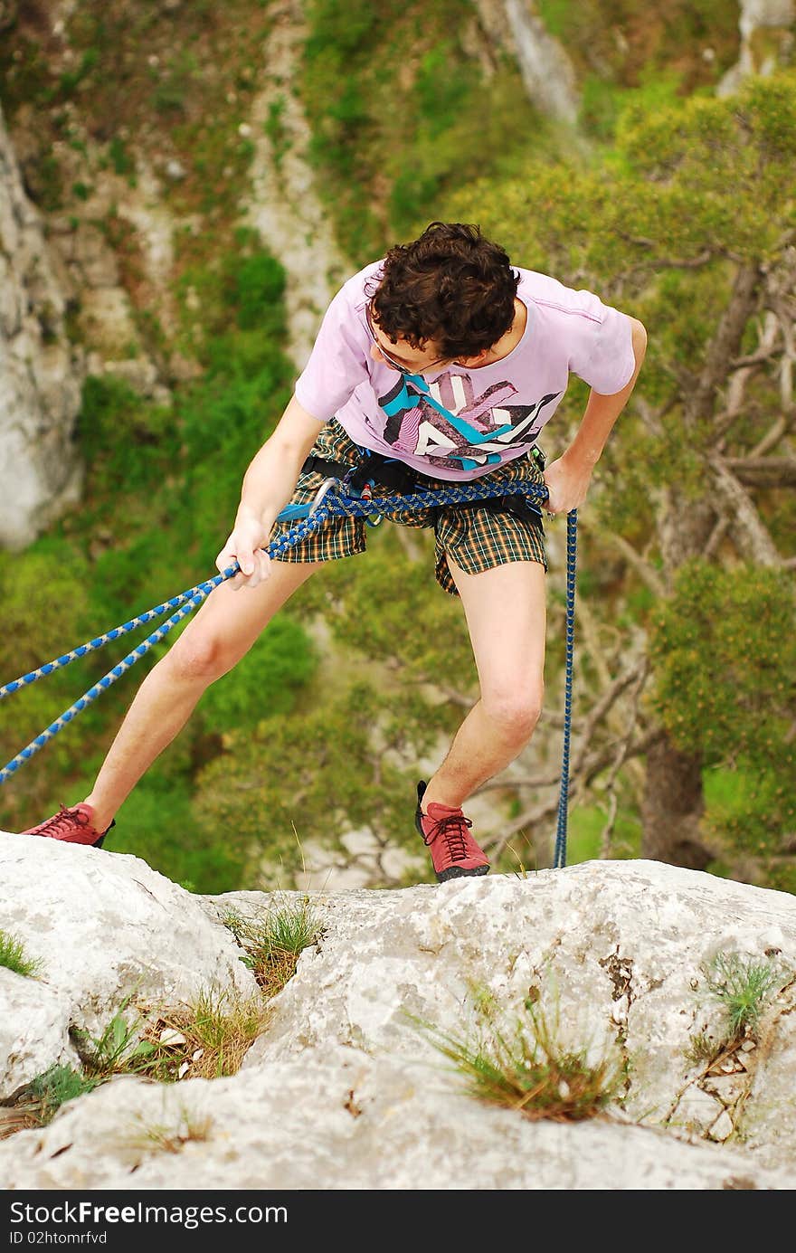 Climber in rappel after finishing the climb. Climber in rappel after finishing the climb