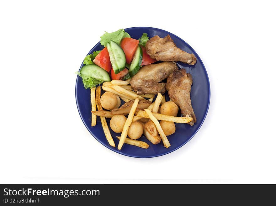 Vegetables, chicken wings, French fries in a plate. Vegetables, chicken wings, French fries in a plate