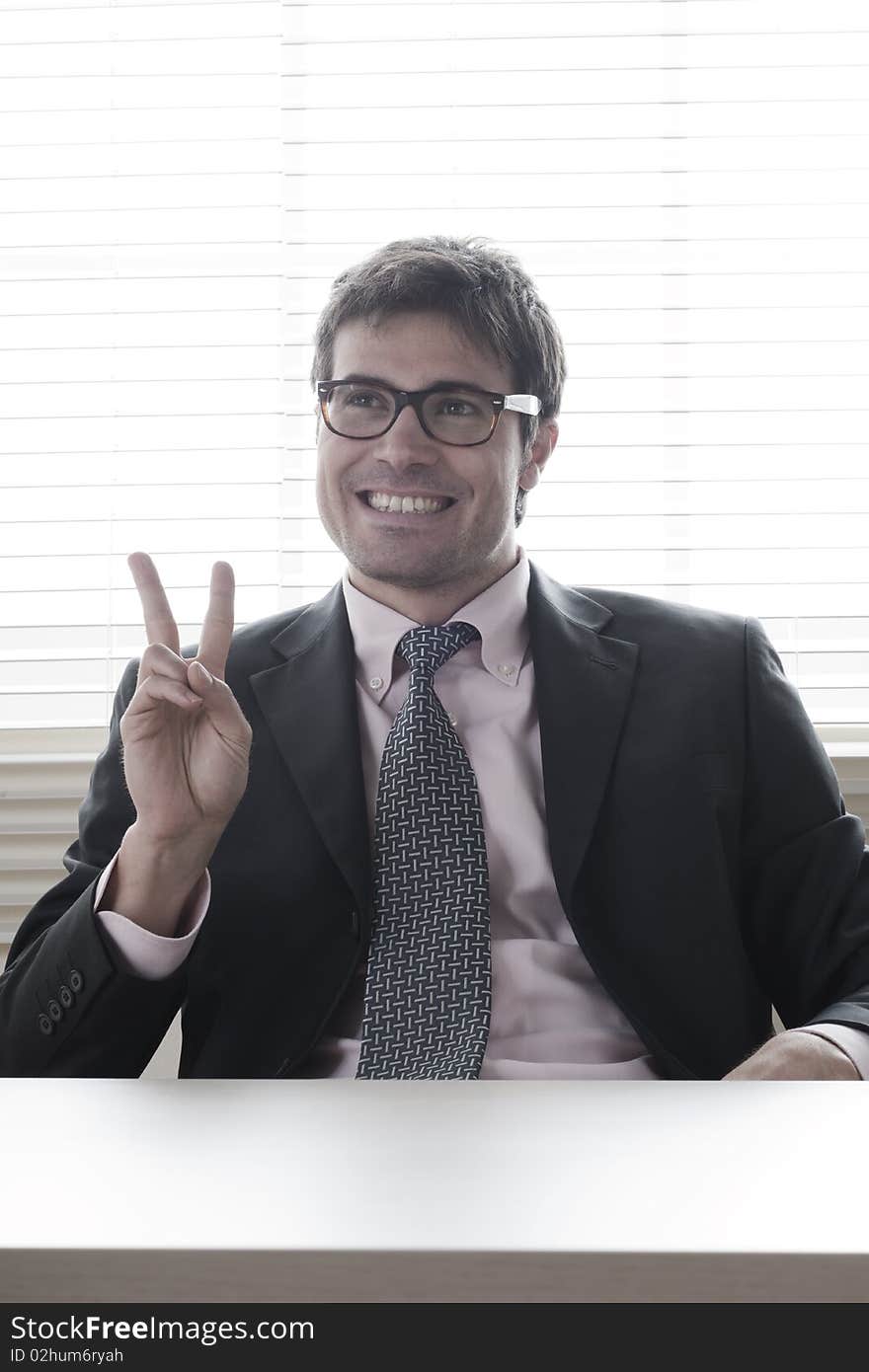 Businessman showing the victory sign. Businessman showing the victory sign