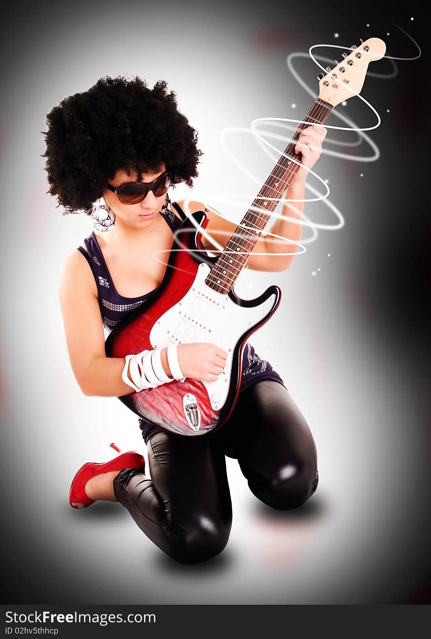 Young guitarist girl holding guitar with lights effect