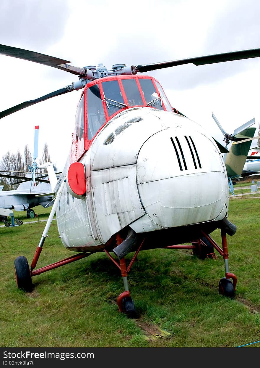 Old helicopter parked in grass airfield