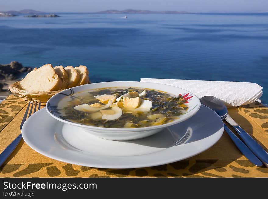 Vegetable soup with eggs on the table against the background of the sea. Vegetable soup with eggs on the table against the background of the sea...