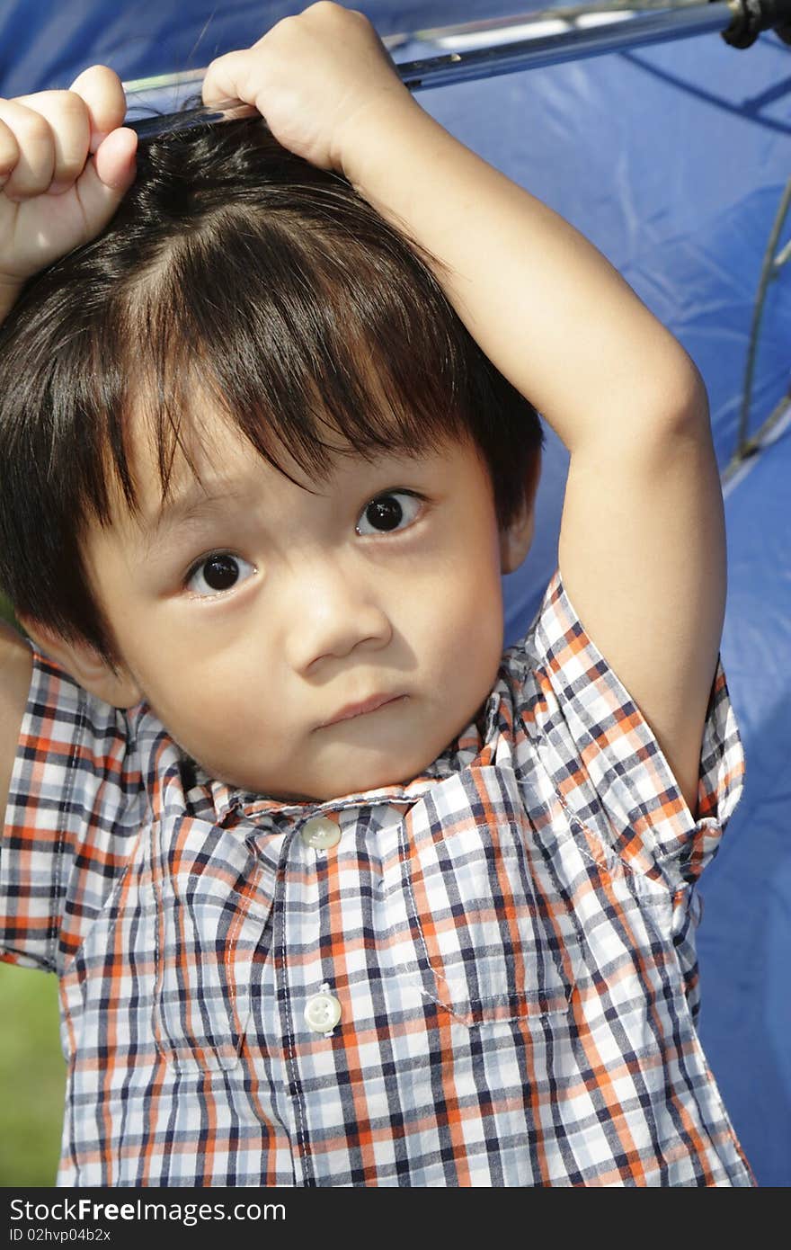 An Asian boy playing with an umbrella. An Asian boy playing with an umbrella