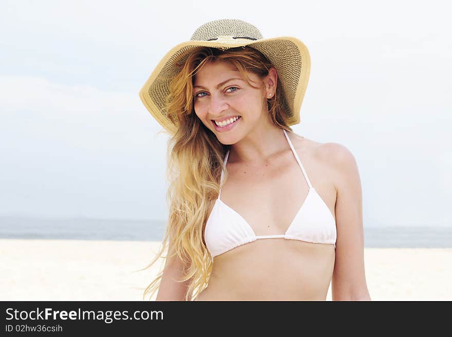 Beautiful woman on the beach with hat and copy space