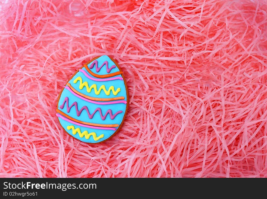 Close up of easter egg cookie on pink ribbons as background.