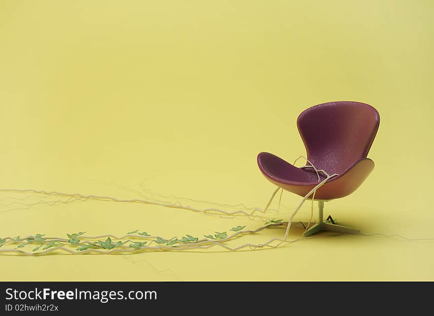 Purple leather chair entwined with ivy on a yellow background