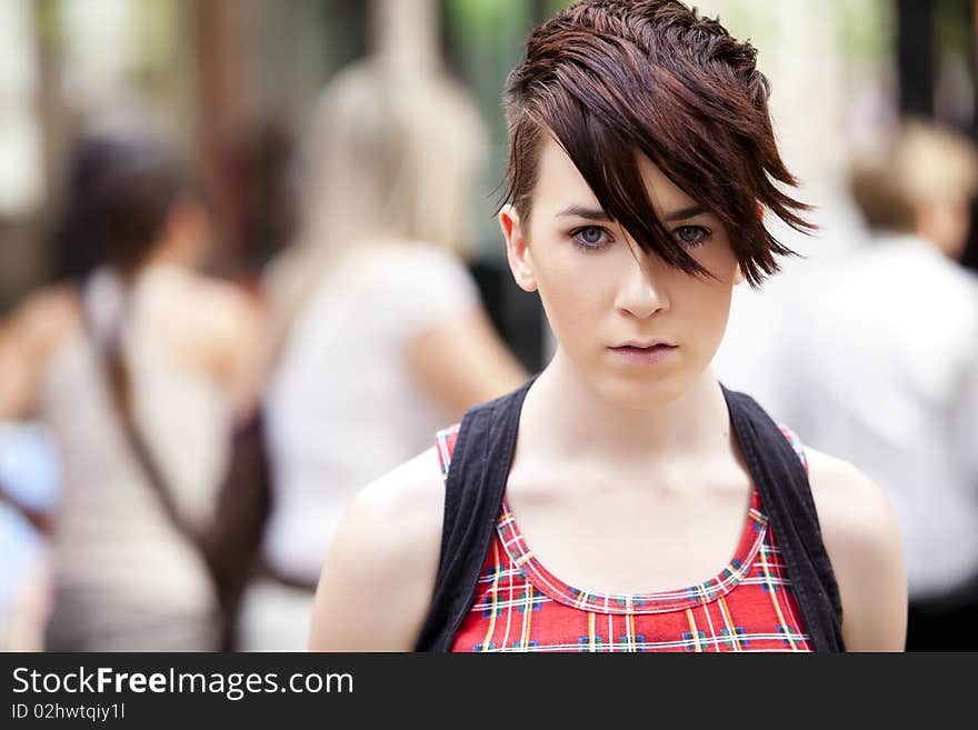 Young modern looking girl over urban background. Young modern looking girl over urban background