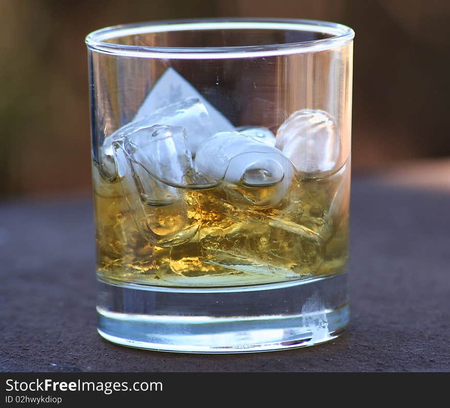 Whiskey in a glass tumbler with ice cubes