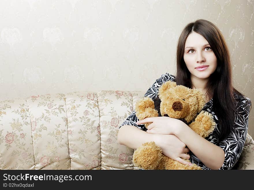 The image of a beautiful pregnant woman sitting on a vintage couch