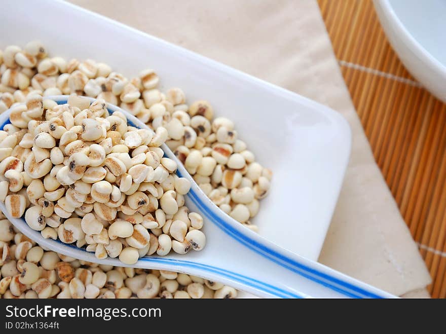 Dried barley seeds on a spoon. Commonly used as a food ingredient in many Chinese cuisine and desserts. For food and beverage, and diet and nutrition concepts. Dried barley seeds on a spoon. Commonly used as a food ingredient in many Chinese cuisine and desserts. For food and beverage, and diet and nutrition concepts.