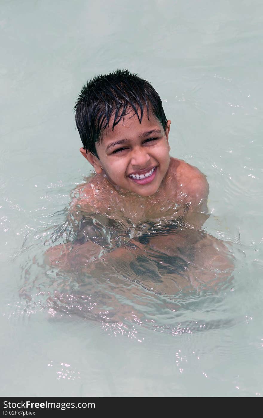 An handsome Indian kid playing in the water